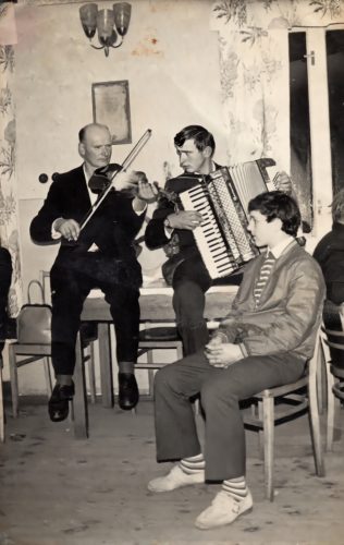 CZESŁAW KOTOWSKI (gra na skrzypcach), syn zamordowanych JÓZEFA i EWY KOTOWSKICH, oraz jego syn i wnuk ofi ar ANTONI KOTOWSKI (gra na akordeonie). Na krześle siedzi EDMUND KOTOWSKI, również wnuk zamordowanych. Zdjęcie powojenne.